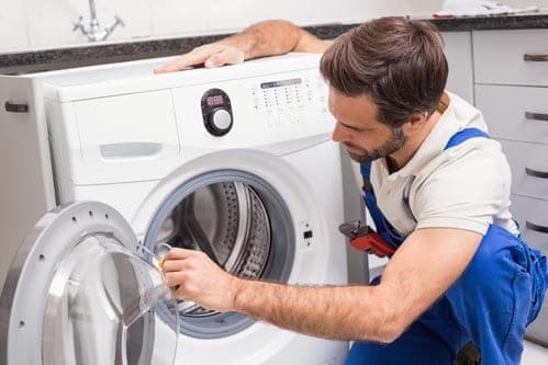 Monteur repareert een wasmachine