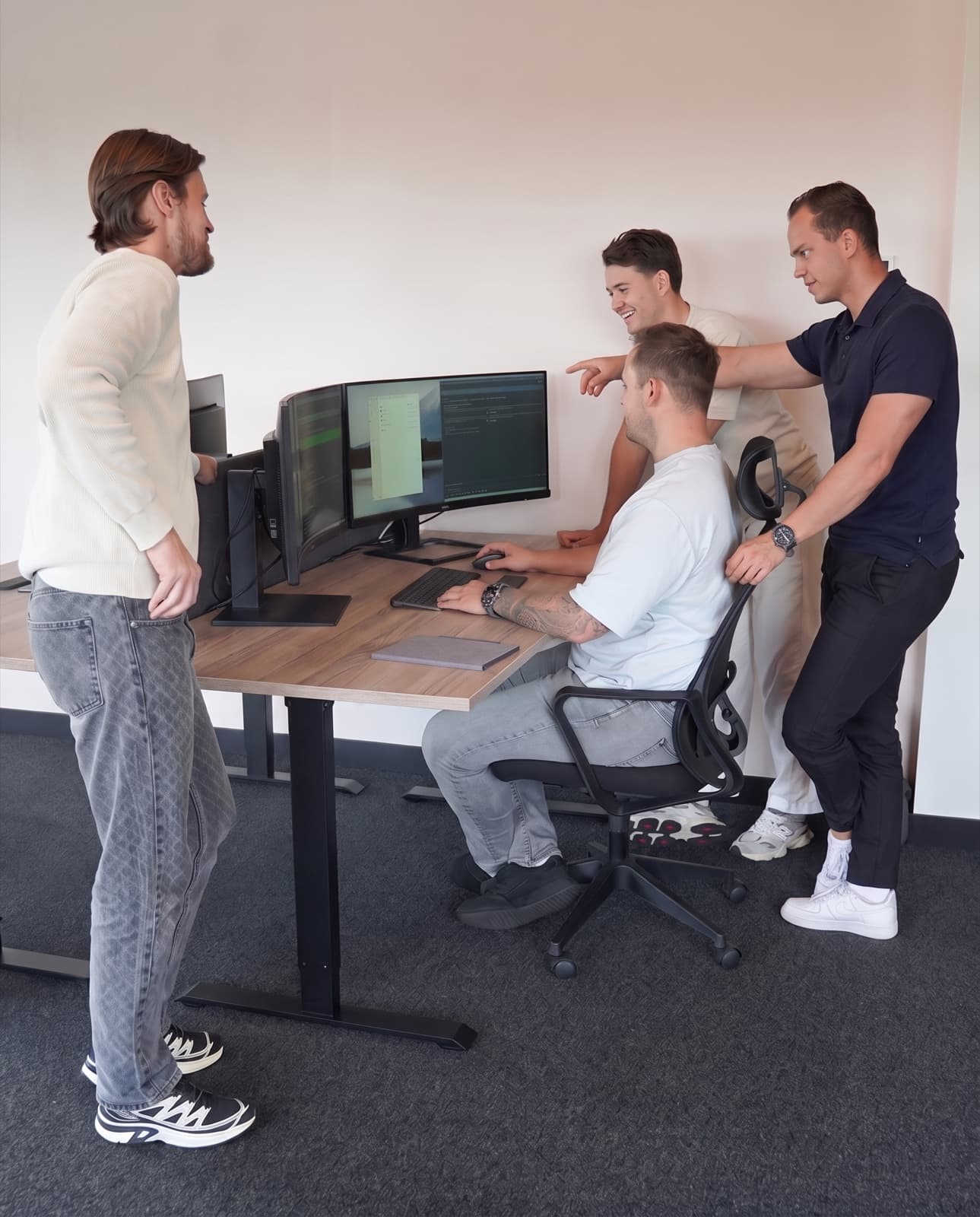 Vier teamleden van Vindbaar.ai werken samen aan een website op kantoor